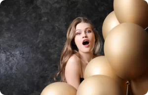 Topless Waitresses hide behind balloons.